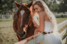 A woman is petting a Cowboy horse in a field. (Zilker Belts)