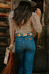 A woman wearing Save Muny jeans and a Zilker Belts cowboy hat.