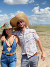 A man and woman posing for a photo in the desert with their Zilker Belts ACL.