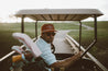 A man sitting in a golf cart wearing a Zilker Belts' ATX Rope Hat.