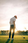 A man is playing Argentina golf at sunset wearing Zilker Belts.