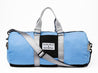 A Zilker x Old Enfield blue duffel bag with a black strap from Zilker Belts.