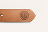 A Texas Exes tan leather belt with a logo on it by Zilker Belts.