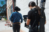 A man in a cowboy hat is holding a Vagabond camera with a Zilker Belts hand-stitched belt.