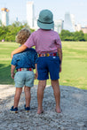 Two boys standing on a rock with a view of the city wearing Waterloo Kids belts by Zilker Belts.