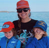A woman and two children wearing Zilker Belts ATX Rope Hats on a boat.