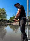 A man standing on a dock holding a Zilker Belts fishing rod named Argentina.