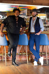 Two men posing in front of a bar wearing Zilker Bolo Ties by Zilker Belts.