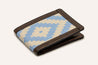 The Bouldin Creek Wallet by Zilker Belts is a handcrafted leather wallet featuring a brown leather border and stitching, with an Argentine woven fabric in a geometric blue and beige pattern.