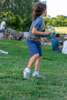 A child is playing with a Verde Kids ball in a park. (Brand: Zilker Belts)