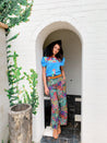 A woman is standing in a doorway wearing a Zilker Belts Cowboy blouse and pants.