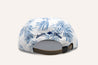 An Imperial Summer Hat by Zilker Belts with palm leaves on it.