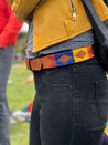 A woman wearing a Kite Fest belt from Zilker Belts with colorful patterns.