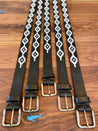 Four Midnight Rider belts on a wooden table.