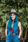 a woman with blue hair wearing Zilker Belts overalls and a hat.
