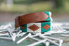 A green and white Save Muny belt with golf tees on it by Zilker Belts.