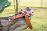 A Native leather belt sitting on top of a cactus by Zilker Belts.