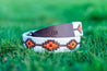 An ATX Dark leather bracelet from Zilker Belts on the grass.